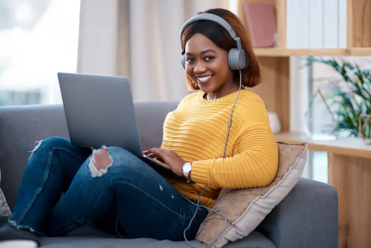 Student with headphones studying from home on a laptop doing an online qualification